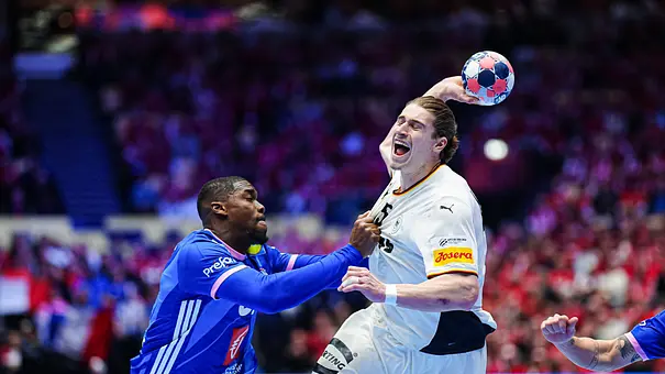 Juri Knorr macht einen Sprungwurf und wird dabei von einem französischen Gegenspieler gedeck. - Foto:  IMAGO / Eibner