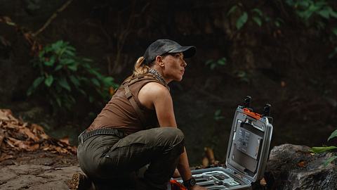Scarlett Johannsson untersucht etwas in einer Hölle in Jurassic World: Die Wiedergeburt - Foto: © Universal Studios. All Rights Reserved.