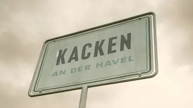 Straßenschild von Kacken an der Havel. - Foto: © 2024 Netflix, Inc.