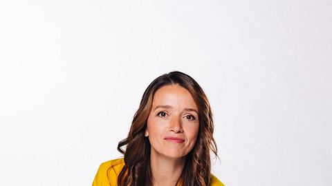 Kaja Schmidt-Tychsen im gelben Anzug mit gewelltem Haar. Sie lächelt direkt in die Kamera. - Foto: RTL / Julia Feldhagen