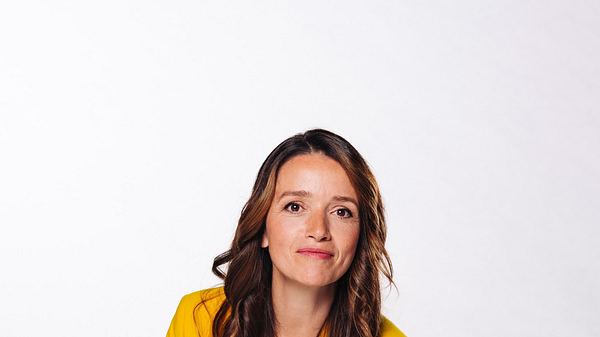 Kaja Schmidt-Tychsen im gelben Anzug mit gewelltem Haar. Sie lächelt direkt in die Kamera. - Foto: RTL / Julia Feldhagen