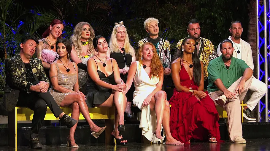KDRS Gruppenbild der Kandidatinnen und Kandidaten von „Kampf der Realitystars“, die bei einer Abendveranstaltung gemeinsam auf einer Bühne sitzen und gespannt nach vorne schauen.