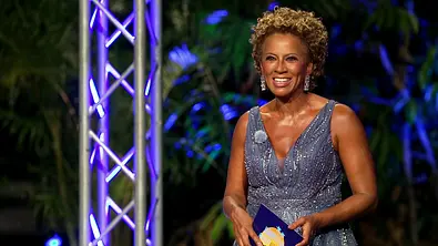 Arabella Kiesbauer während des Finales der RealityAllstar 2026-Staffel im blauen Glitzerkleid und mit Moderationskarte am Strand. - Foto: © RTLZWEI Arabella Kiesbauer während des Finales der RealityAllstar 2026-Staffel im blauen Glitzerkleid und mit Moderationskarte am Strand. - Foto: © RTLZWEI