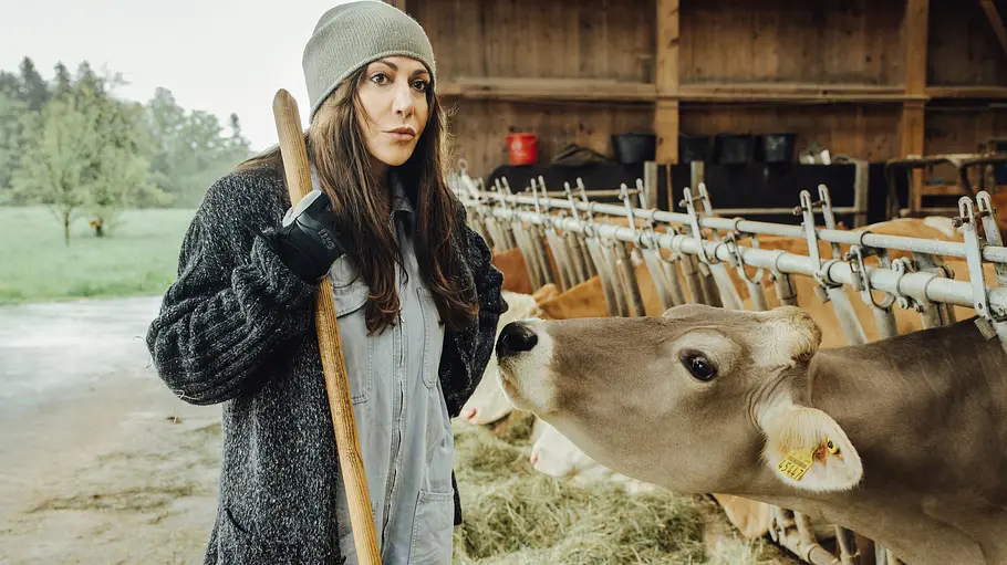 Katja Baumann (Simone Thomalla) macht sich Sorgen um die verschwundenen Eltern, um deren Hof sie sich nun kümmert. Frühling - Die verschwundenen Eltern: Katja Baumann (Simone Thomalla) steht mit einer Mistgabel in einem Stall. Eine Kuh nähert sich ihr an.