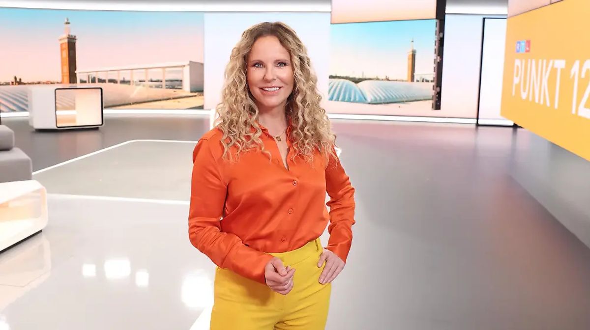 Katja Burkard wird aktuell bei RTL ordentlich gefordert. Katja Burkard steht im „Punkt 12“-Studio, sie lächelt in die Kamera.