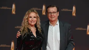 Katja Burkard steht neben ihrem Ehemann Hans Mahr – beide lächeln in die Kamera, Hans hält den Arm um sie. - Foto: IMAGO / Horst Galuschka Katja Burkard steht neben ihrem Ehemann Hans Mahr – beide lächeln in die Kamera, Hans hält den Arm um sie. - Foto: IMAGO / Horst Galuschka