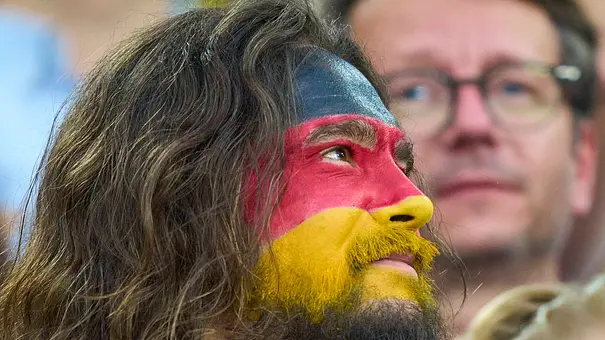 Tom Kaulitz, hier mit Deutschlandflagge im Gesicht im Stadion, wird Fan Experte bei FIFA WM 2026. - Foto: IMAGO / ActionPictures