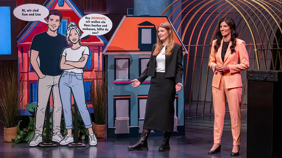 Kein Deal für begeisterte HdL-Spontankäufer, aber eine echte Erleichterung für viele Hausbesitzer. Carolin Krebber (l.) und Leonie Dowling stehen neben bunten Hauskulissen und lebensgroßen Comicfiguren auf einer Bühne.