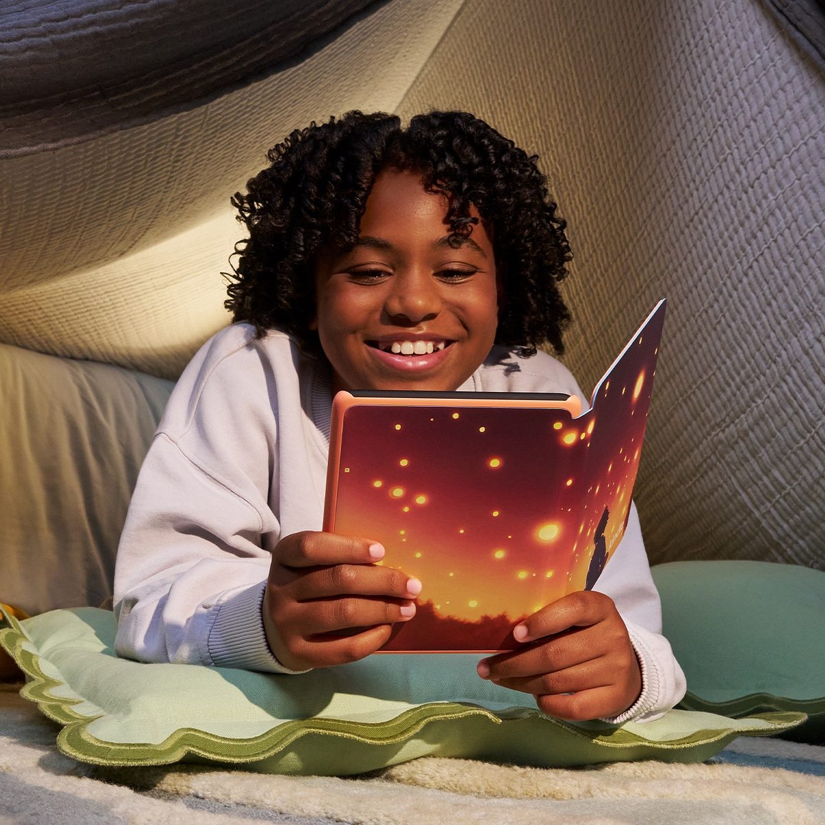 Kindle Colorsoft Kids Ein Mädchen liest lächelnd auf einem Kindle Colorsoft Kids ein Buch.