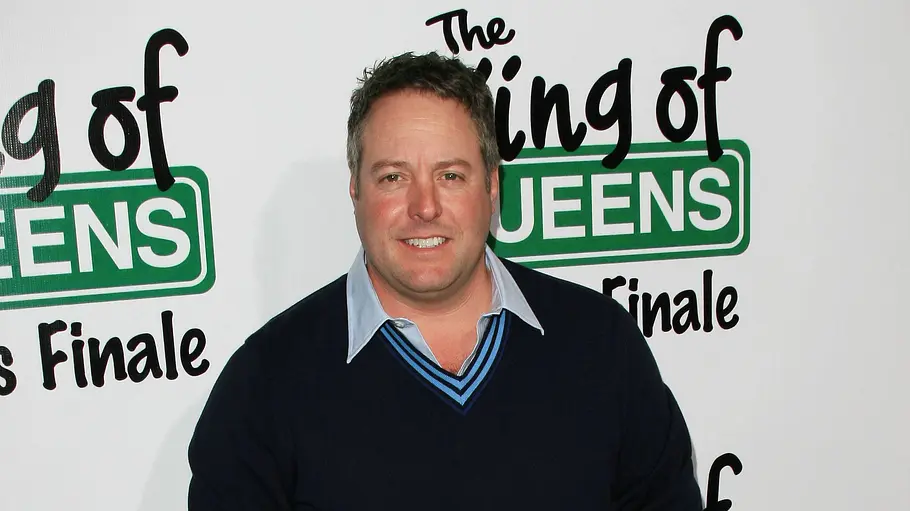 Gary Valentine steht vor der Fotowand des „King of Queens“–Finale