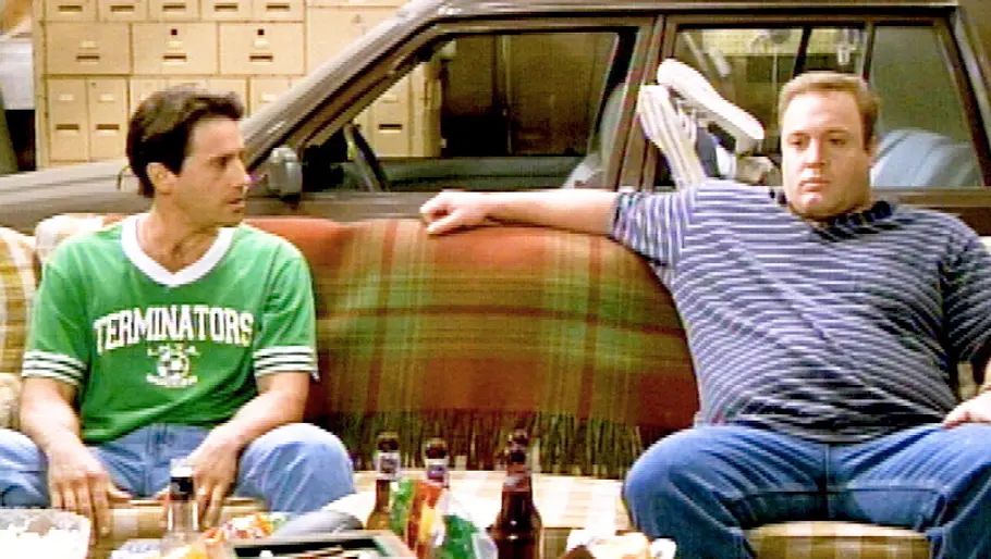 Larry Romano sitzt neben Kevin James auf einem Sofa.