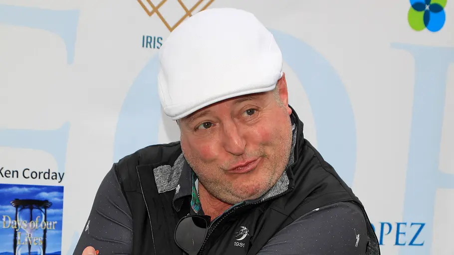Gary Valentine macht vor einer Fotowand ein albernes Gesicht.