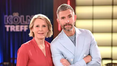 Susan Link und Micky Beisenherz stehen nebeneinander im Studio des „Kölner Treff“, blicken in die Kamera und lächeln - Foto:  IMAGO / Future Image