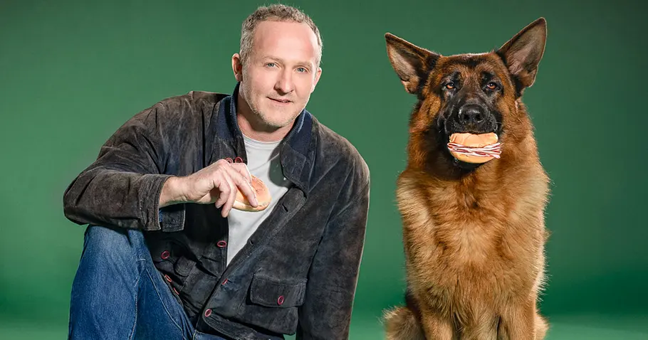 Kommissar Rex-Darsteller Capo Maximilian Brückner mit Hunde-Darsteller „Capo“, einem zweijährigen Schäferhund, hier mit Wurstsemmel im Maul.