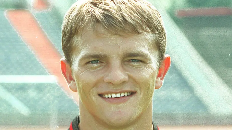 Kreso Kovacec bei Hannover 96 Ex-Bundesliga-Profi Kreso Kovacec lächelt bei einem Porträtfoto in die Kamera, im Hintergrund ist ein Fußballstadion zu sehen.