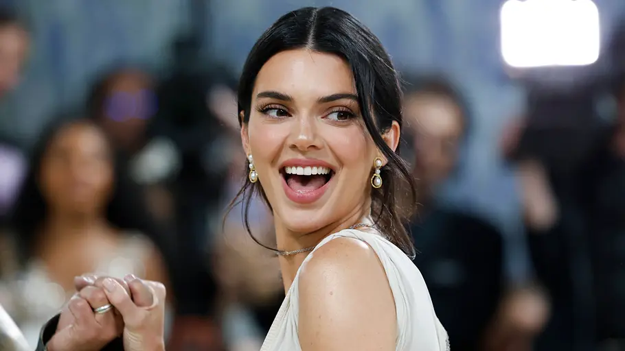 Kendall Jenner Kendall Jenner dreht sich auf dem roten Teppich um und lächelt jemanden an.