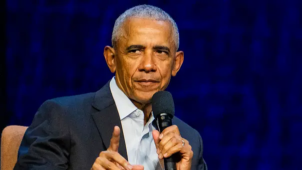 Barack Obama sitzt vor einem blauen Hintergrund auf einem Stuhl und hält ein Mikrofon in der Hand.  - Foto:  IMAGO / NTB