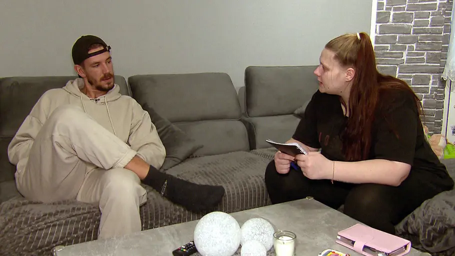 Tim Katzenbauer und Lavinia Wollny sitzen auf einer Couch.