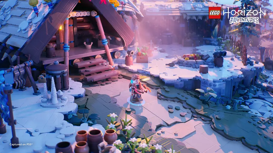 Aloy steht in LEGO Horizon Adventures vor der Hütte von Rost