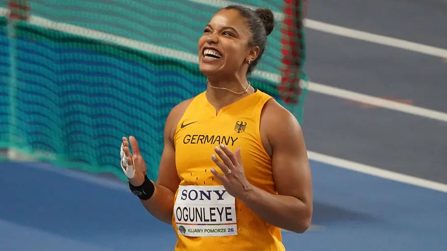 Yemisi Ogunleye will heute im Kugelstoßen siegen. Yemisi Ogunleye lächelt glücklich und hat die Hände gehoben.
