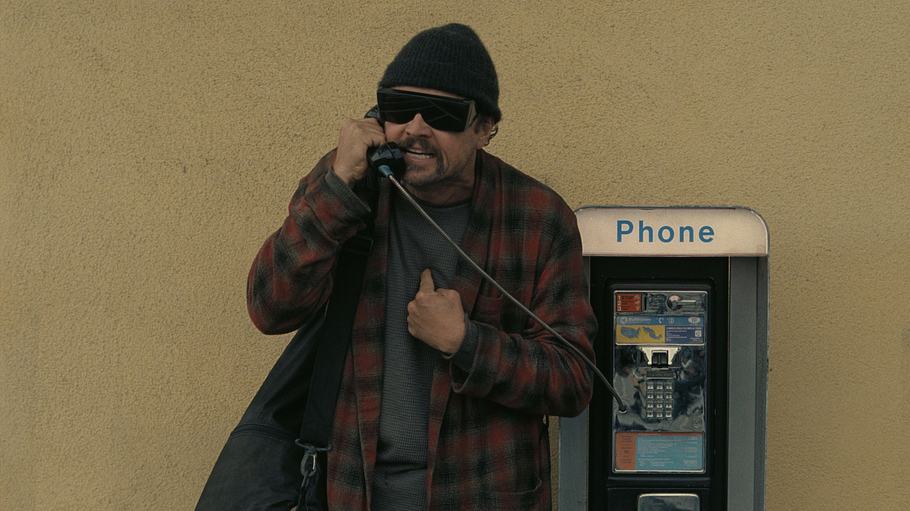 Leonardo DiCaprio schreit als Bob Ferguson im Morgenmantel und XXL-Sonnenbrille in einen Telefonhörer