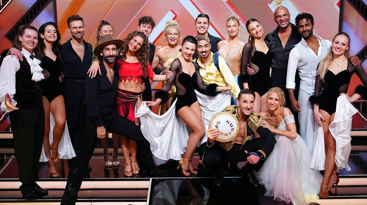 Der Cast von Let's Dance 2024 auf einem Bild vereint. Alle lächeln begeistert in die Kamera. 