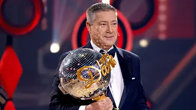 Joachim Llambi steht im Finale von Lets Dance auf der Tanzfläche und hat den Pokal in der rechten Hand - Foto: IMAGO / Panama Pictures