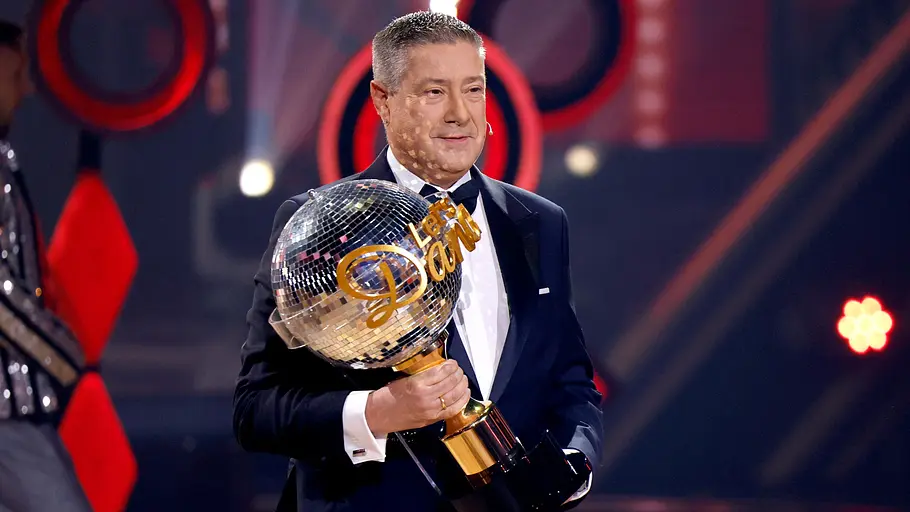 Joachim Llambi Joachim Llambi steht im Finale von Let's Dance auf der Tanzfläche und hat den Pokal in der rechten Hand