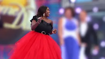 Motsi Mabuse im ausladenden roten Rock neben ihren Jury-Kollegen von „Strictly Come Daning“. Diese sind verschwommen dargestellt, genau wie der Hintergrund. - Foto: IMAGO / ZUMA Press Wire Motsi Mabuse im ausladenden roten Rock neben ihren Jury-Kollegen von „Strictly Come Daning“. Diese sind verschwommen dargestellt, genau wie der Hintergrund. - Foto: IMAGO / ZUMA Press Wire