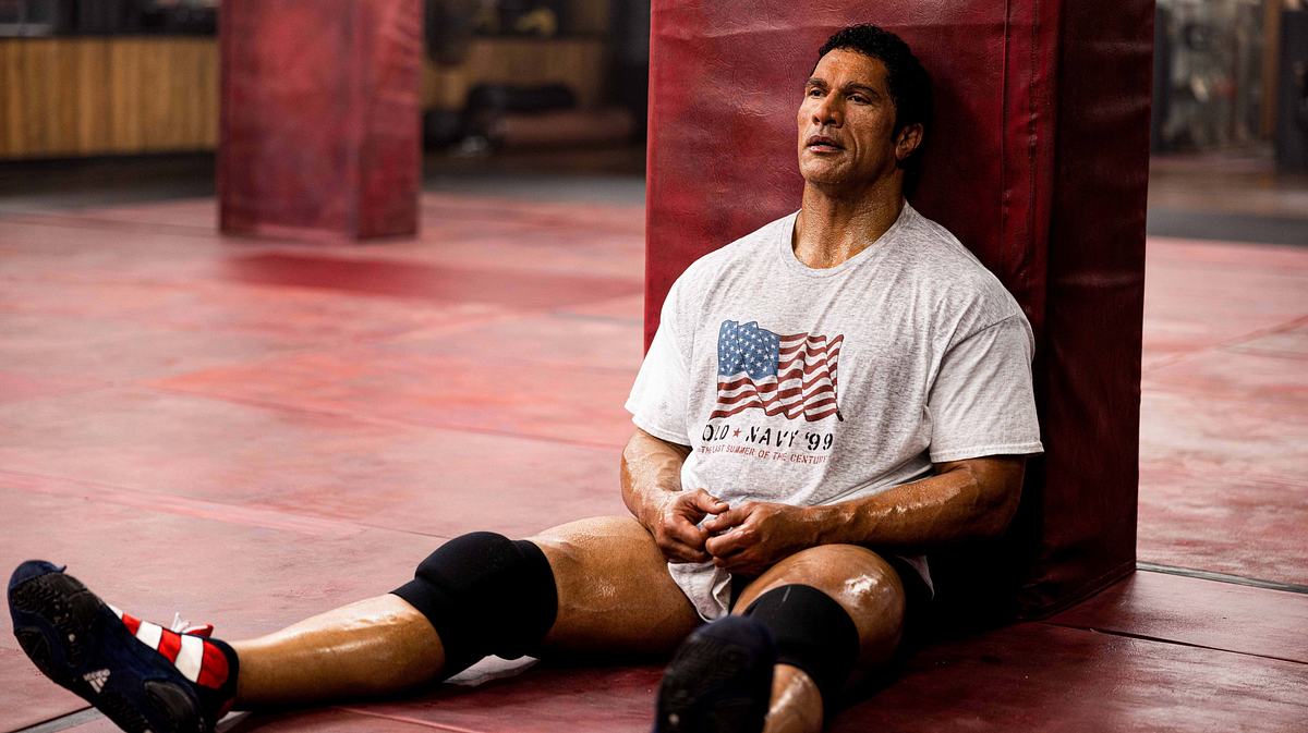 Dwayne Johnson als Mark Kerr lehnt an einer Säule.