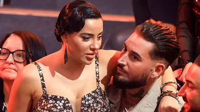 Leyla Lahouar sitzt auf Mike Heiters Schoß und schaut nachdenklich in die Ferne. - Foto: IMAGO / Future Image