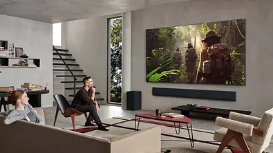 Zwei Personen sitzen in einem stylischen Wohnzimmer, der LG OLED TV G5 2025 hängt wie ein Gemälde an der Wand. - Foto: © 2009-2025 LG Electronics