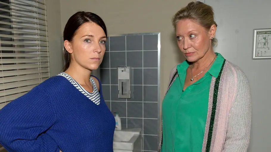 Lilly wird von ihrer Chefin ermahnt. Lilly schaut ernst, während Dr. Albrecht sie skeptisch anblickt.