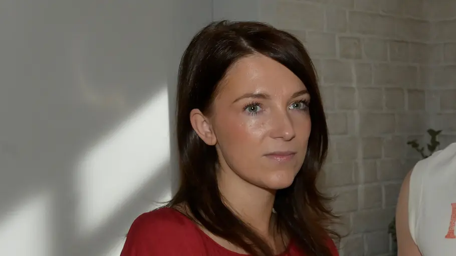 Lilly Iris Mareike Steen GZSZ Lilly in roter Bluse steht neben Moritz im ärmellosen „Rodeo Club“-Shirt. Beide blicken ernst nach rechts.