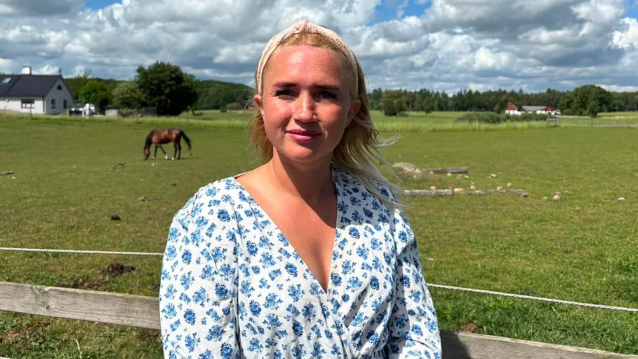 Linnea vor einer Weide im blauen Kleid.