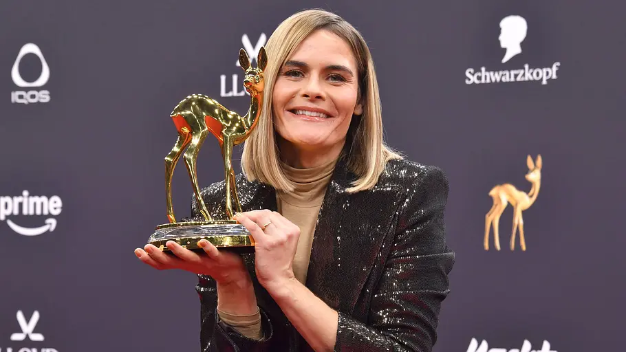 Hazel Brugger mit Bambi Hazel Brugger hält einen Goldenen Bambi auf dem roten Teppich in der Hand und lacht stolz