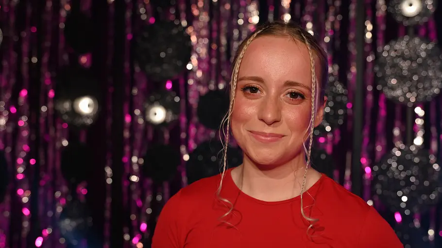 Maria Ziffy steht vor pinken Girlanden und lächelt.