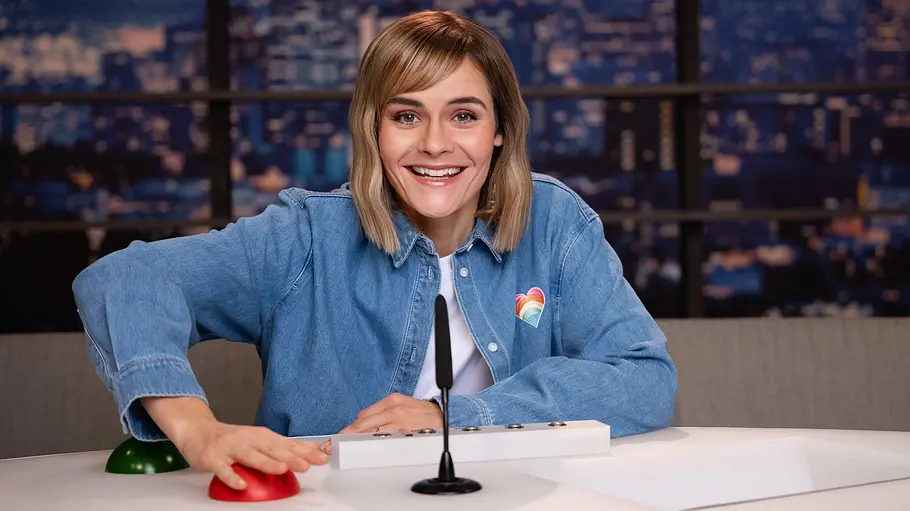 LOL Next: Hazel Brugger Hazel Brugger lacht in die Kamera, während sie den roten LOL-Buzzer drückt.