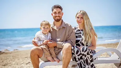 Loredana Wollny sitzt mit Servet und Aurelio am Strand. - Foto: RTL2