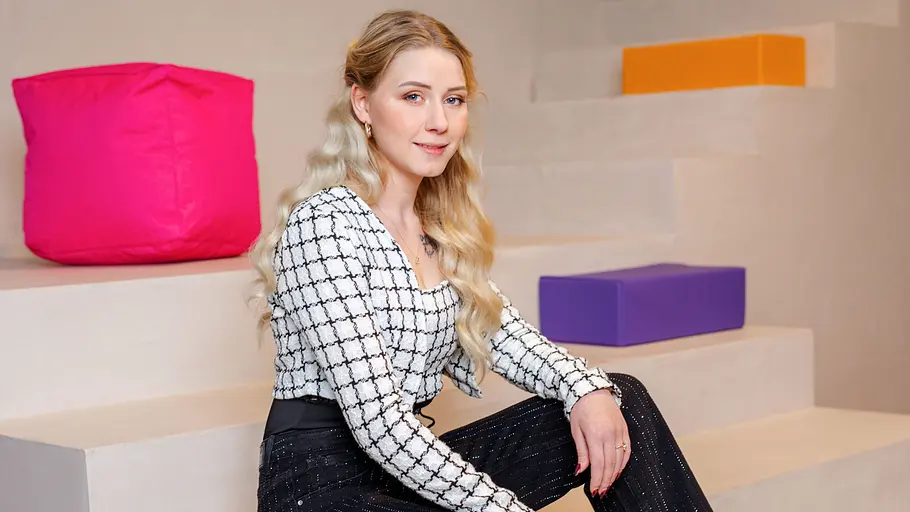 Loredana Wollny Loredana Wollny sitzt auf einer Treppe vor bunten Elementen.