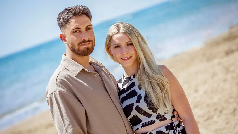 Loredana Wollny und Servet posieren am Strand. 