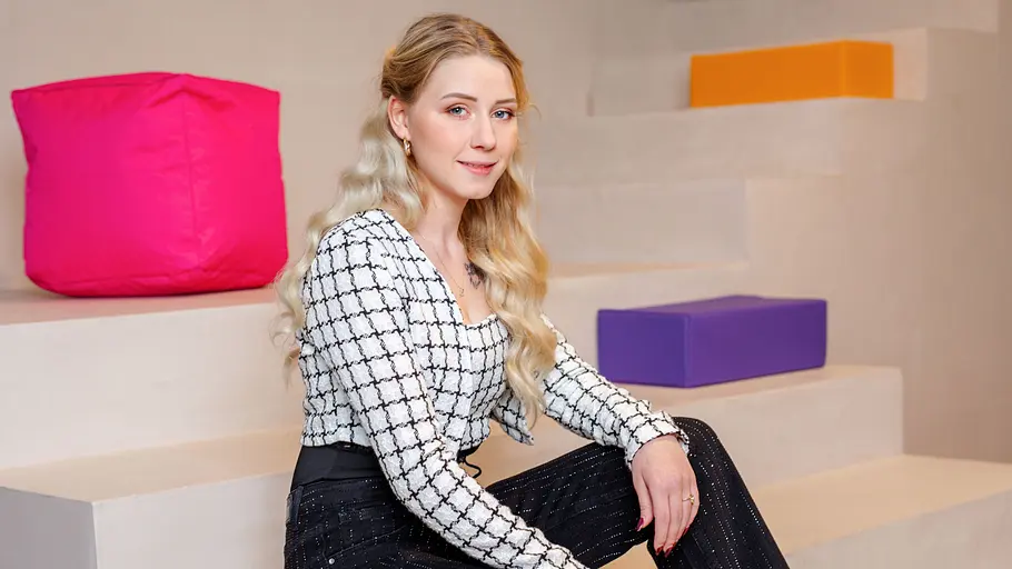 Loredana Wollny Loredana Wollny sitzt auf einer Treppe vor bunten Elementen.