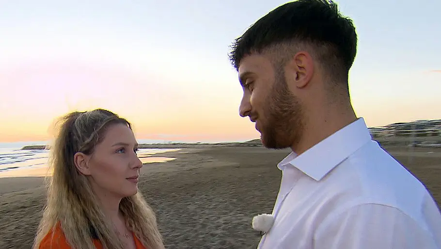 Loredana Wollny und Servet stehen sich am Strand gegenüber