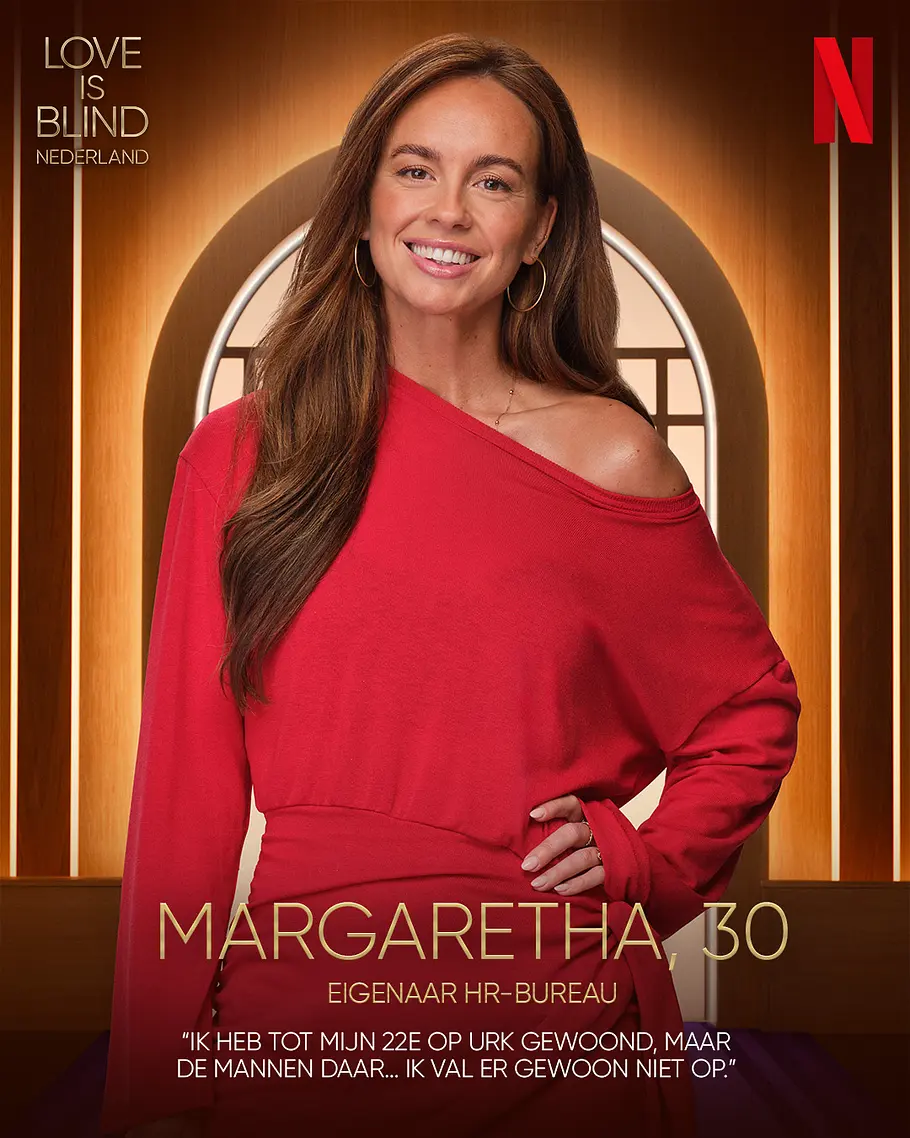 Love is Blind: Netherlands-Kandidat Margaretha Alter, Beruf Margaretha lächelt in einem roten, einseitig schulterfreien Kleid auf einem Werbeplakat für „Love is Blind Nederland“.