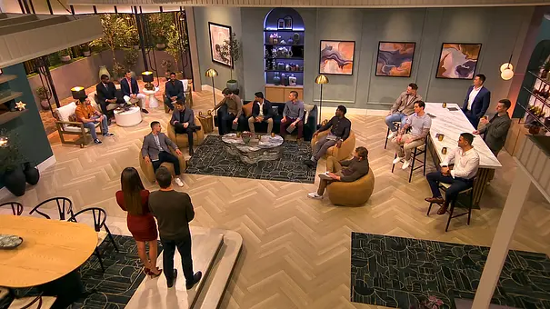 Die Kandidat:innen von „Love is Blind“ sitzen verteilt im Wohnzimmer der Villa - Foto: COURTESY OF NETFLIX Die Kandidat:innen von „Love is Blind“ sitzen verteilt im Wohnzimmer der Villa - Foto: COURTESY OF NETFLIX