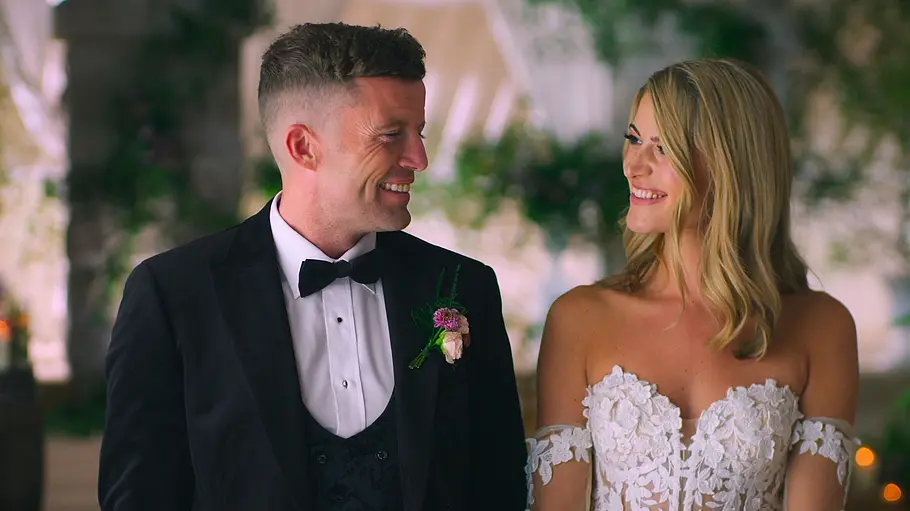 Ashleigh und Billy stehen nebeneinander und lächeln sich an.