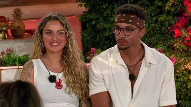 Chiara mit langen Locken sitzt neben David mit Brille und Bandana. Beide tragen Weiß; hinter ihnen sind Pflanzen. - Foto: RTLZwei Chiara mit langen Locken sitzt neben David mit Brille und Bandana. Beide tragen Weiß; hinter ihnen sind Pflanzen. - Foto: RTLZwei