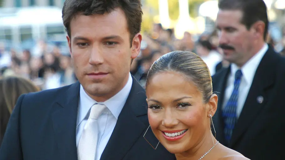 Jennifer Lopez und Ben Affleck posieren bei einem Event eng nebeneinander, während sie lächelt und er ernst in die Kamera blickt.