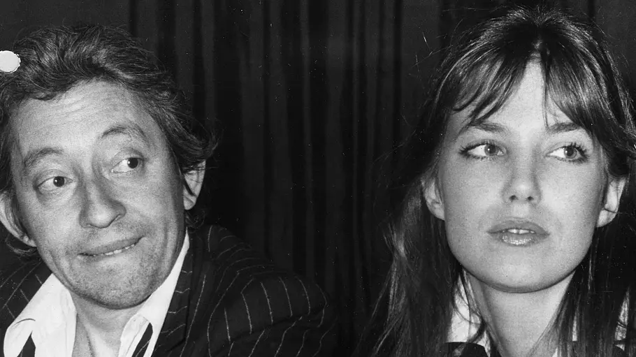 Serge Gainsbourg und Jane Birkin sitzen auf einer Schwarz-Weiß-Aufnahme nebeneinander und blicken in unterschiedliche Richtungen.