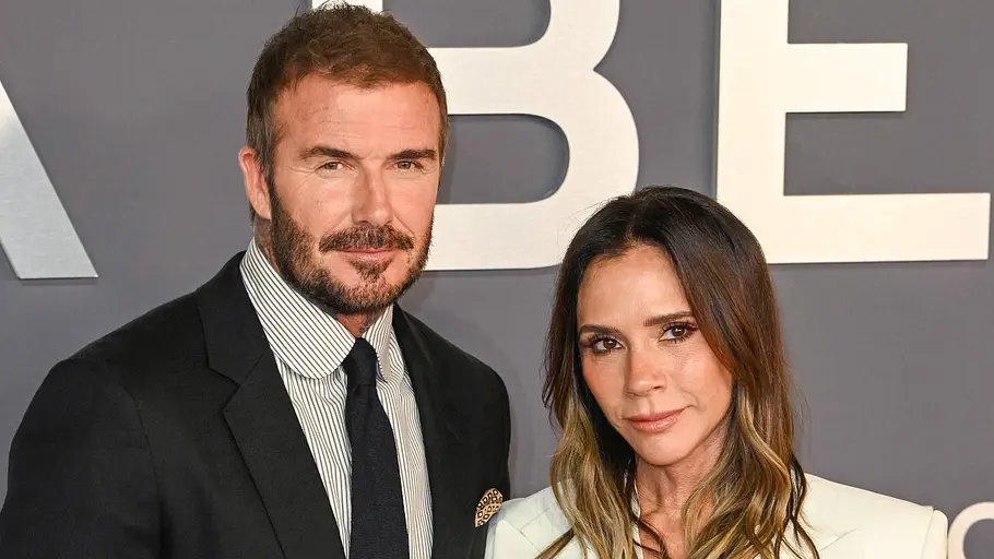 Victoria und David Beckham posieren elegant bei einem Event nebeneinander und blicken in die Kamera.